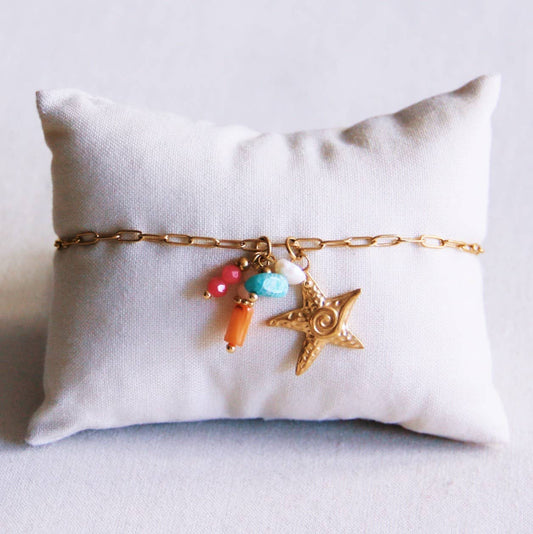 Tobillera de cadena con estrella de mar y un racimo de piedras preciosas.