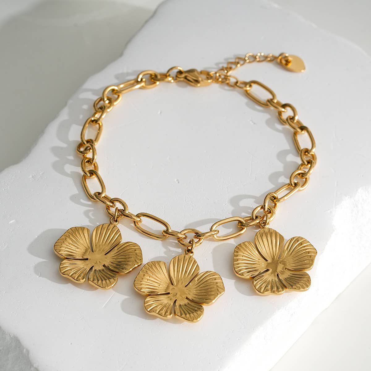 Pulsera de cadena dorada con tres flores colgantes